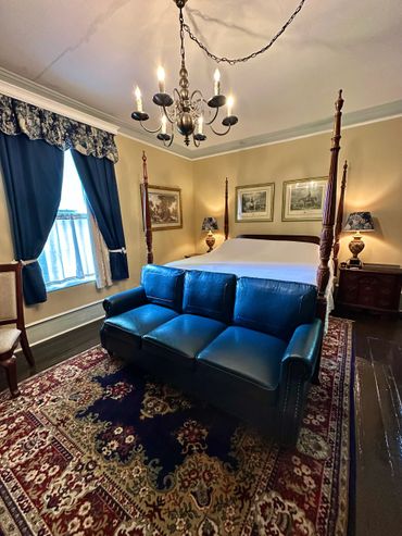 Elegant Room 1 with a four-poster bed and blue leather couch in room private Bathroom