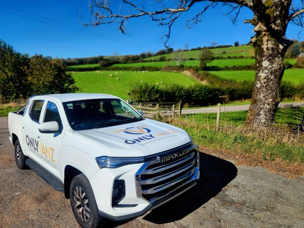White Maxus pickup truck with OnlyVanz branding in a rural setting.