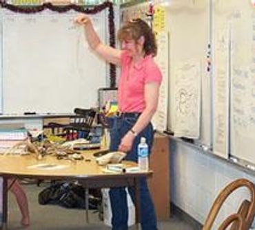 A woman stands wearing a pink t shirt with gins