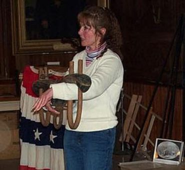 A woman stands wearing a white shirt