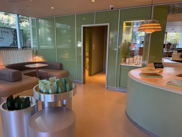 Modern waiting area with green walls and curved furniture.