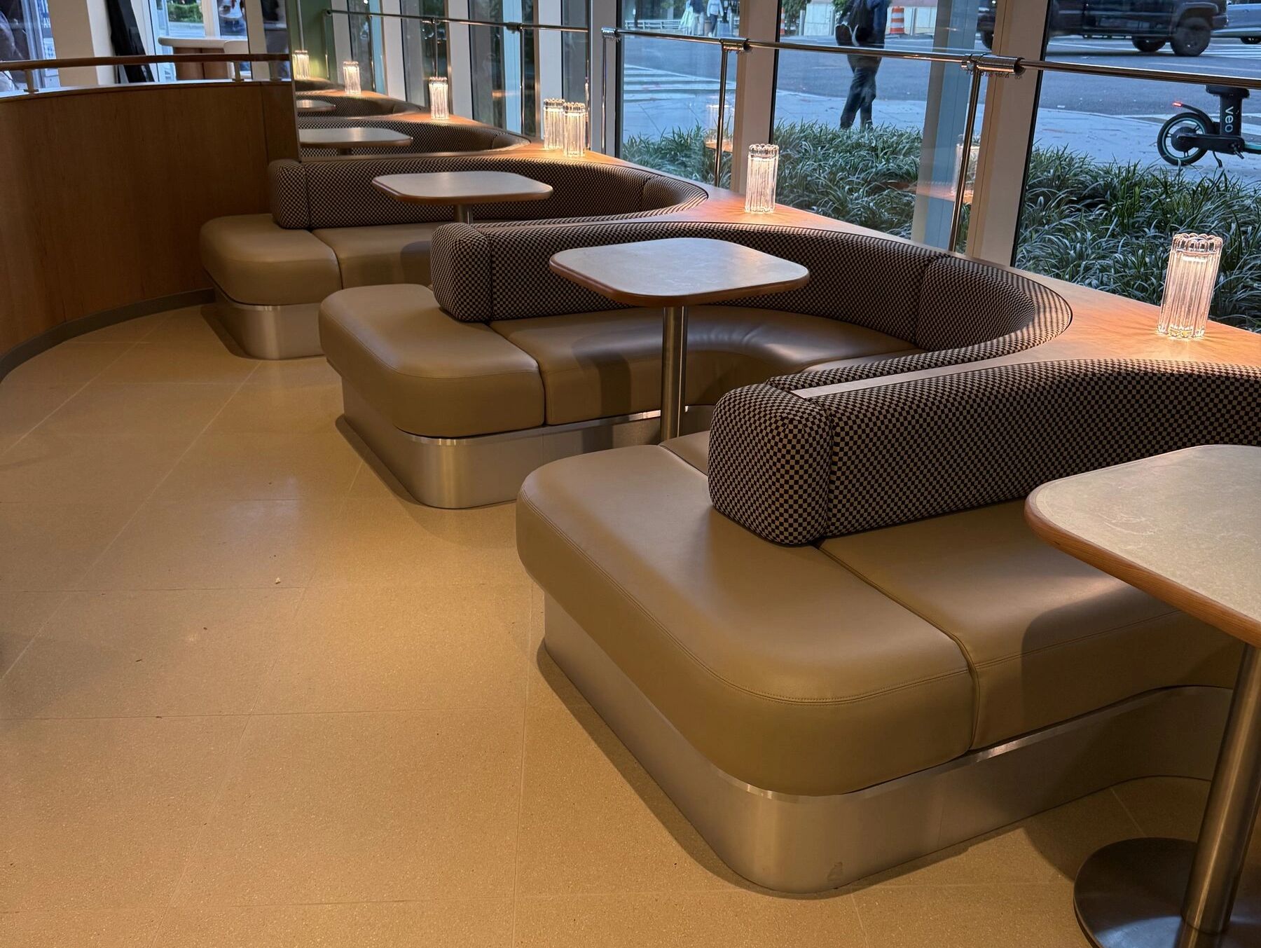 Curved upholstered banquettes on millwork bases in a hospitality interior