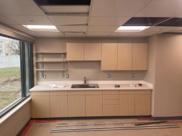 Wood-grain laminate kitchenette casework with quartz top