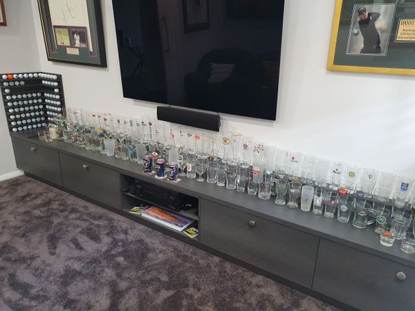 Home bar display golf memorabilia, and entertainment unit under wall-mounted TV