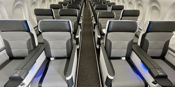 Spacious, modern airplane seats in a premium cabin with ample legroom.