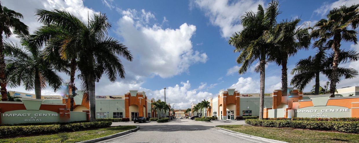 Acebo Health center entrance to Impact Center at Doral with main street and buildings.