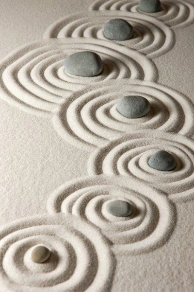 Pierres disposées dans du sable avec des cercles concentriques.