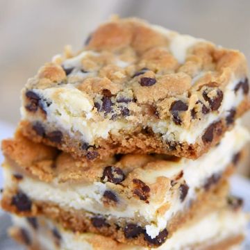 Stack of chocolate chip cookie bars with creamy filling.
