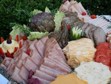 Assorted deli meats and cheeses arranged on a platter.
