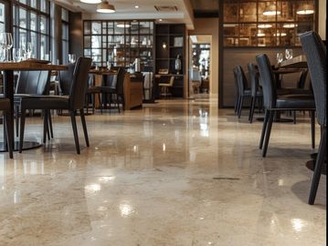 A modern, high-end restaurant interior featuring a sleek, glossy epoxy floor in a neutral tone.