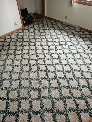 Room with patterned carpet and wooden trim.
