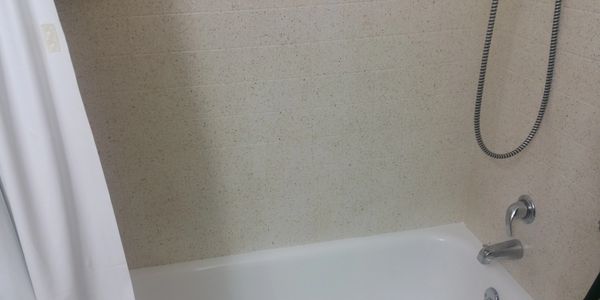 Stone Fleck tile surround and refinished bathtub