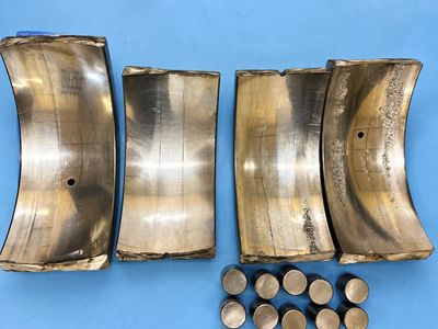 Used engine bearing shells with wear and deposits.