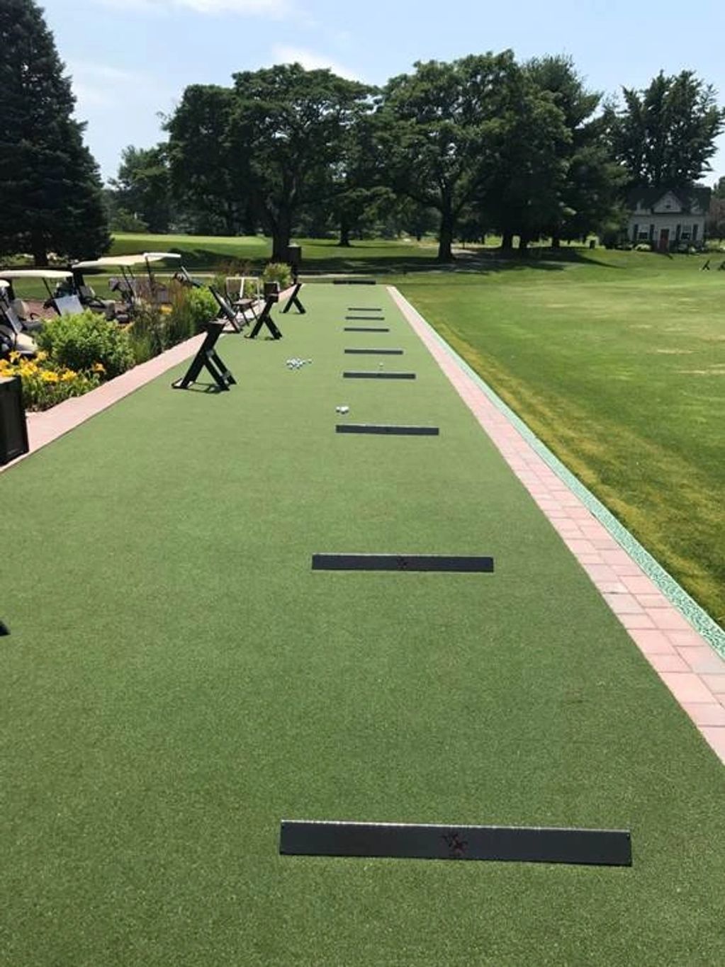 Golf driving range with golf balls and practice mats.