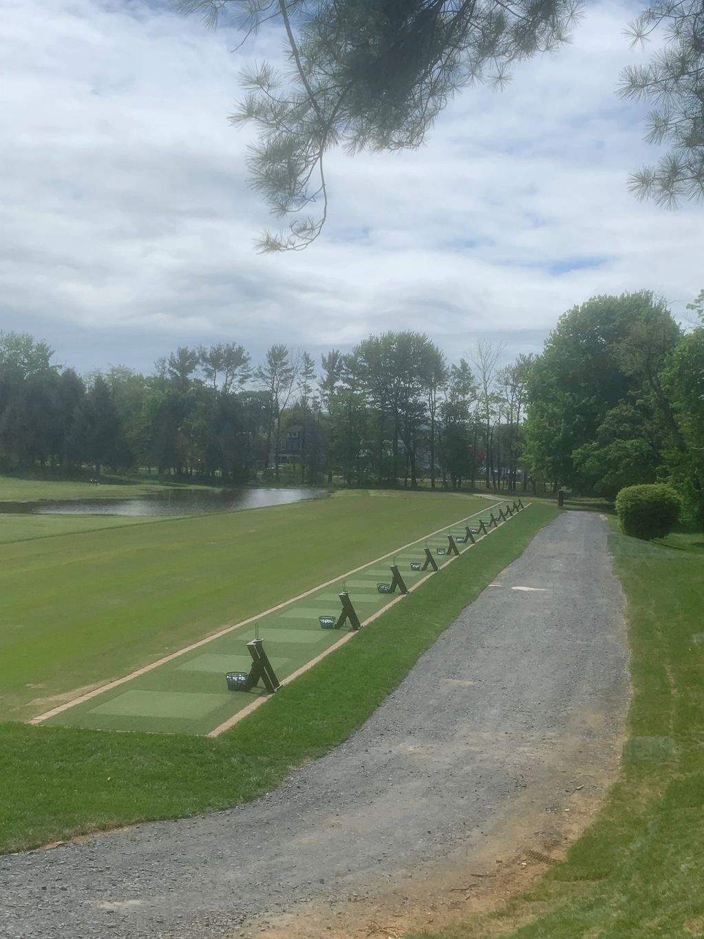 Golf driving range with green mats and baskets of balls.