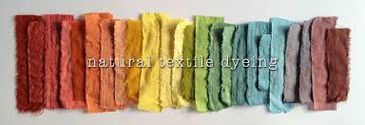 Colorful natural textile dye samples arranged in a rainbow gradient.