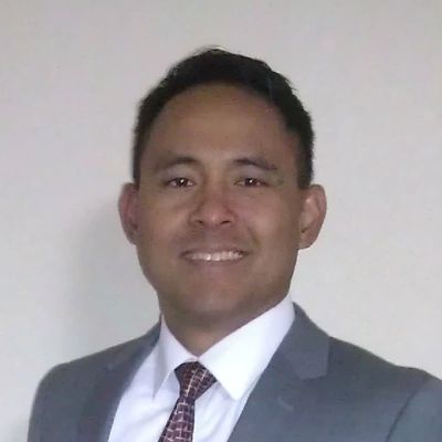 Man in a suit smiling at the camera.
