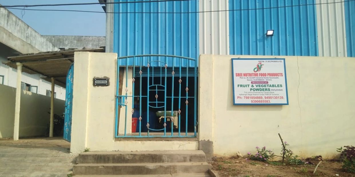Entrance of a blue and white building with a metal gate.