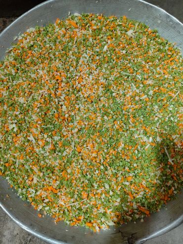 Large tray filled with finely chopped mixed vegetables.