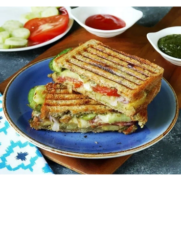Grilled sandwich with vegetables and cheese on a blue plate.