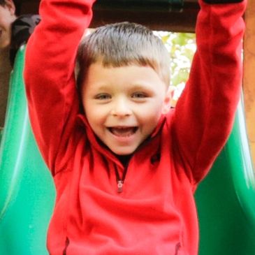Boy sliding down a sliding board at school