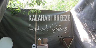 Sign for Kalahari Breeze handmade sabans inside a tent.