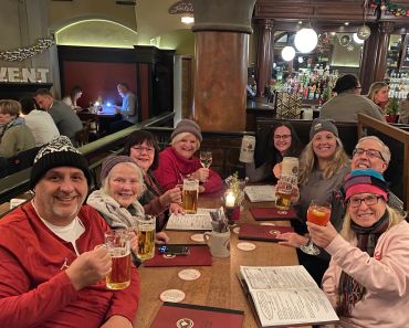 Group of friends enjoying drinks and smiles at a cozy pub.
