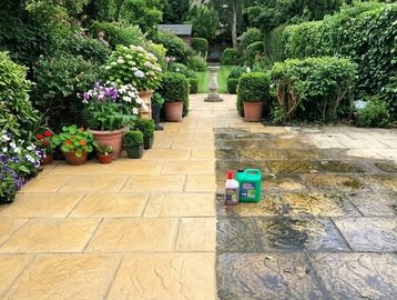 A garden pathway half cleaned, showing a stark contrast between dirty and clean tiles.