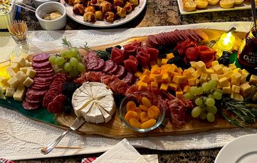 An elegant charcuterie board with meats, cheeses, fruits, and appetizers on a festive table.