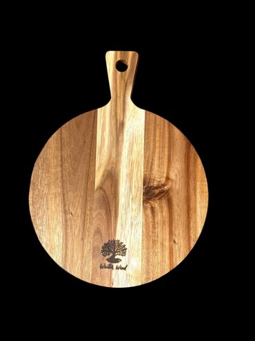 Round wooden cutting board with handle and engraved tree logo.