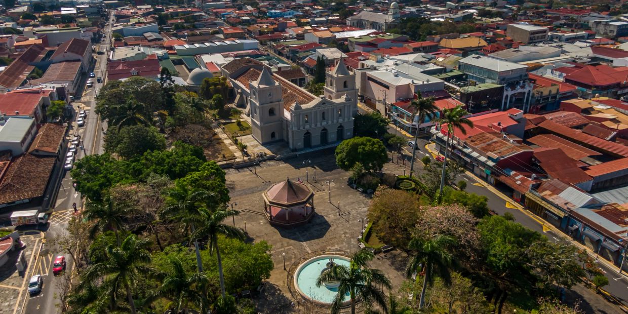 Aerial view of a historic town square with a church and fountain.