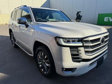 White luxury SUV parked outside a building.