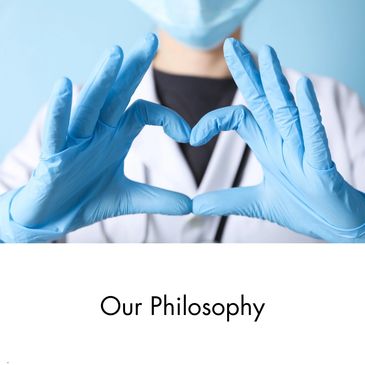 A person wearing blue surgical gloves making a heart shape with their fingers.