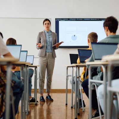 A woman stands in front of a classroom.