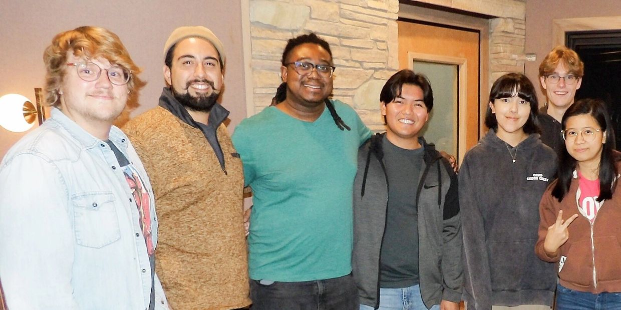 A diverse group of seven friends smiling and posing indoors.