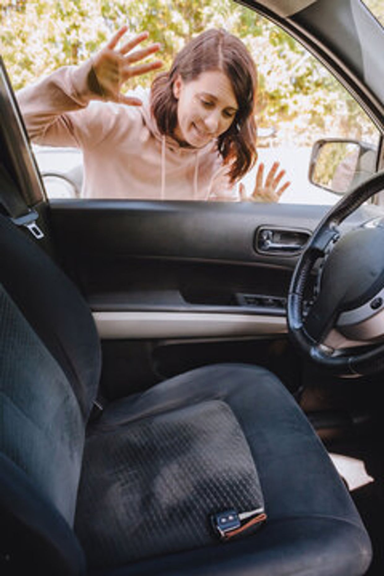Woman looking into a car at a set of keys on the seat.. Team Astro Towing. Houston car lockout service. pop a lock Houston. affordable lockout services houston