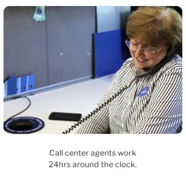 A call center agent is smiling while talking on the phone.