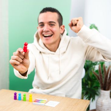 A man holding the red pawn and celebrating winning the card