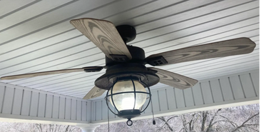 a ceiling fan on a porch with a light on it