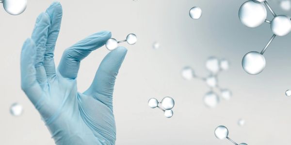 A gloved hand holding a molecular model sphere representing scientific research.