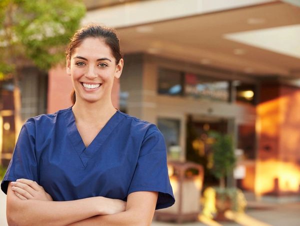 Portrait Of Female Doctor Standing Outside Hospital