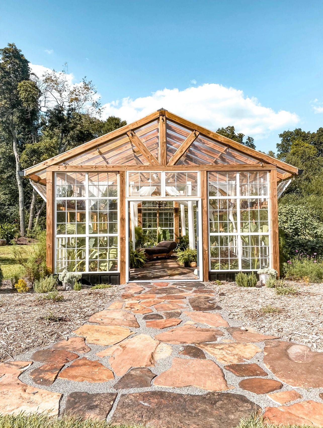 Greenhouse front facing with brick pathway leading to entrance