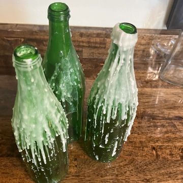 green bottles with melted wax