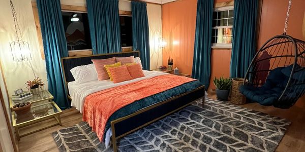 Coral and turquoise room with king bed and hanging chair