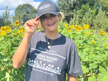 Woman tipping hat in sunflower field