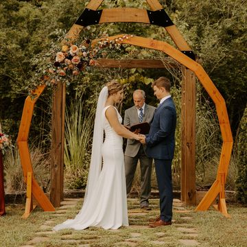 Bride and groom standing in front of geometric arch