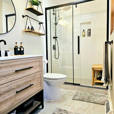Modern bathroom with glass shower and wooden vanity.