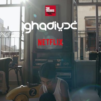 A boy sitting on the floor in a sunlit room with vintage furniture and a TV.