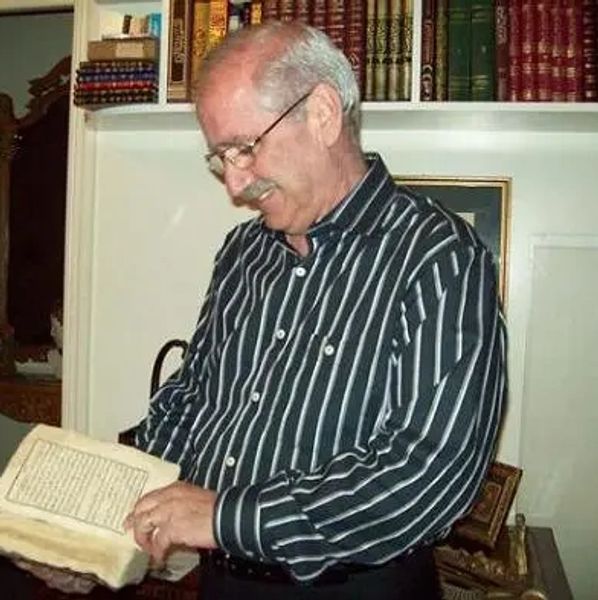 نهاد سمعان يتصفح مخطوط أثري من مكتبته الضخمة