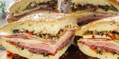 Close-up of a large Italian sandwich with layers of meats and cheese.